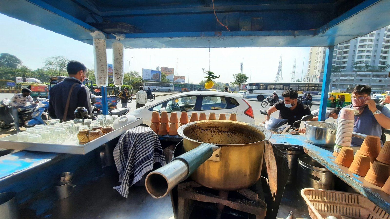 a group of people standing around a metal pot